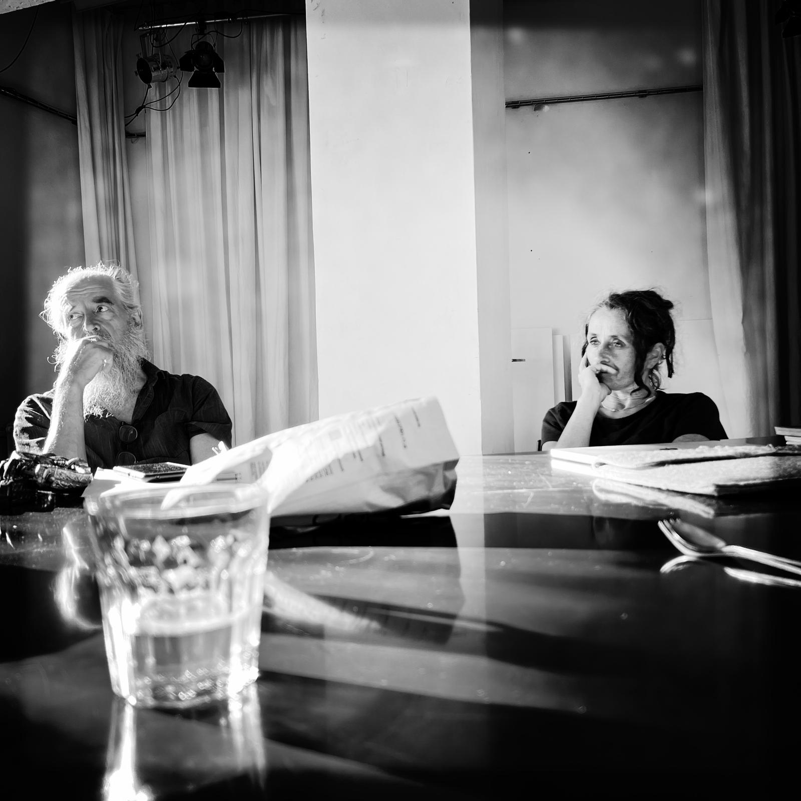 Schwarz-weiß Bild von zwei Personen, die an einem Tisch sitzen und sich unterhalten
